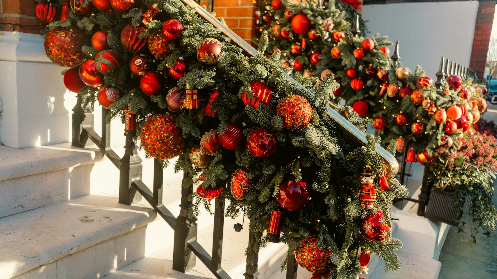 Christmas garland with red ornaments on a staircase railing