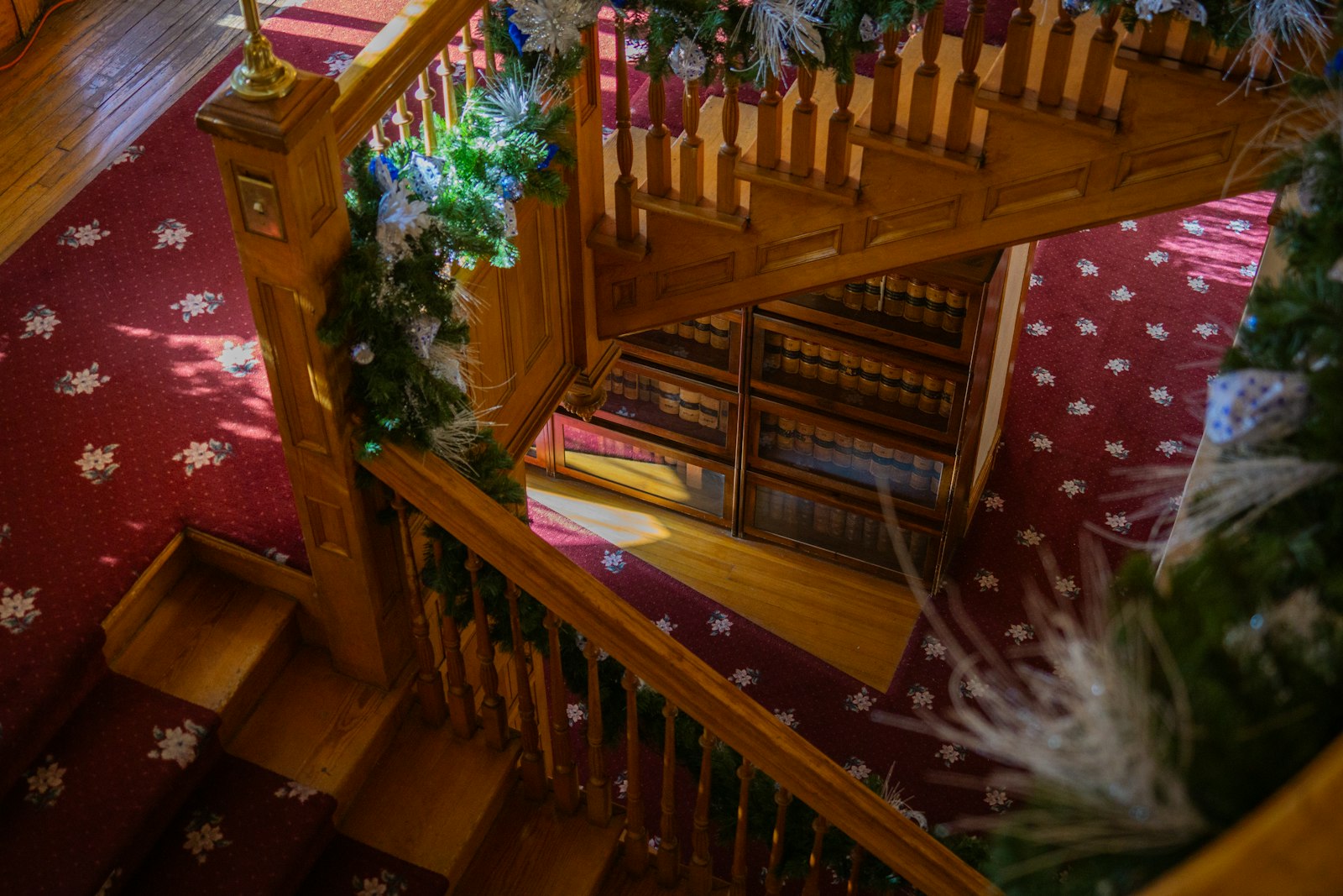 Wooden staircase decorated with festive greenery and lights