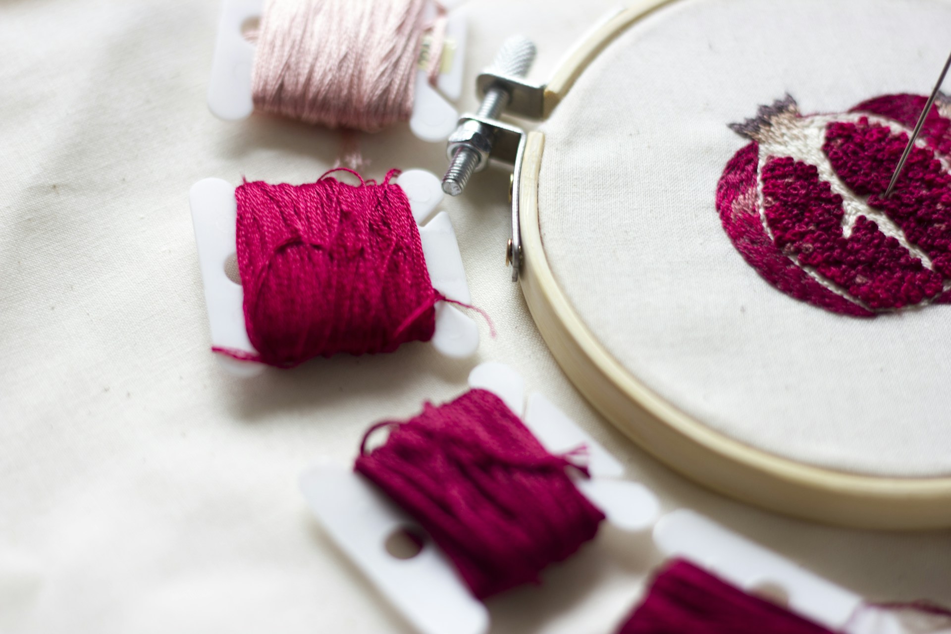 DIY Christmas stockings embroidery supplies: red floss and a wooden hoop on linen