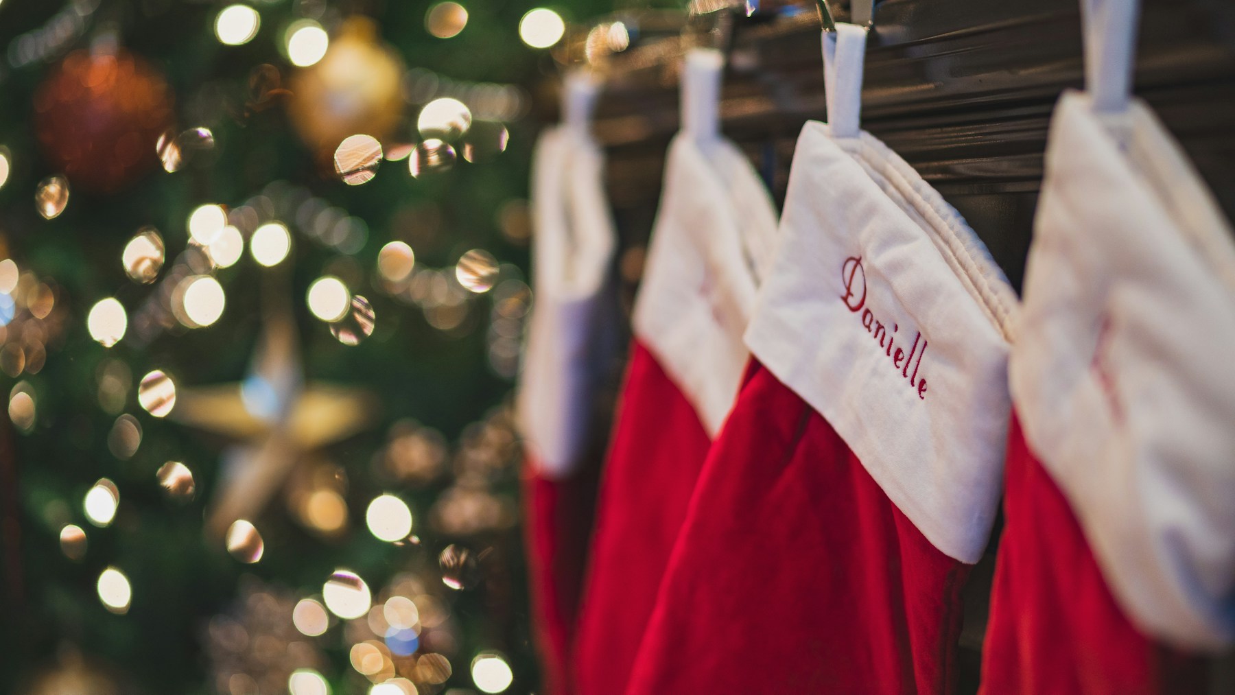 DIY Christmas stockings in red with fluffy white cuffs in a row with twinkle lights