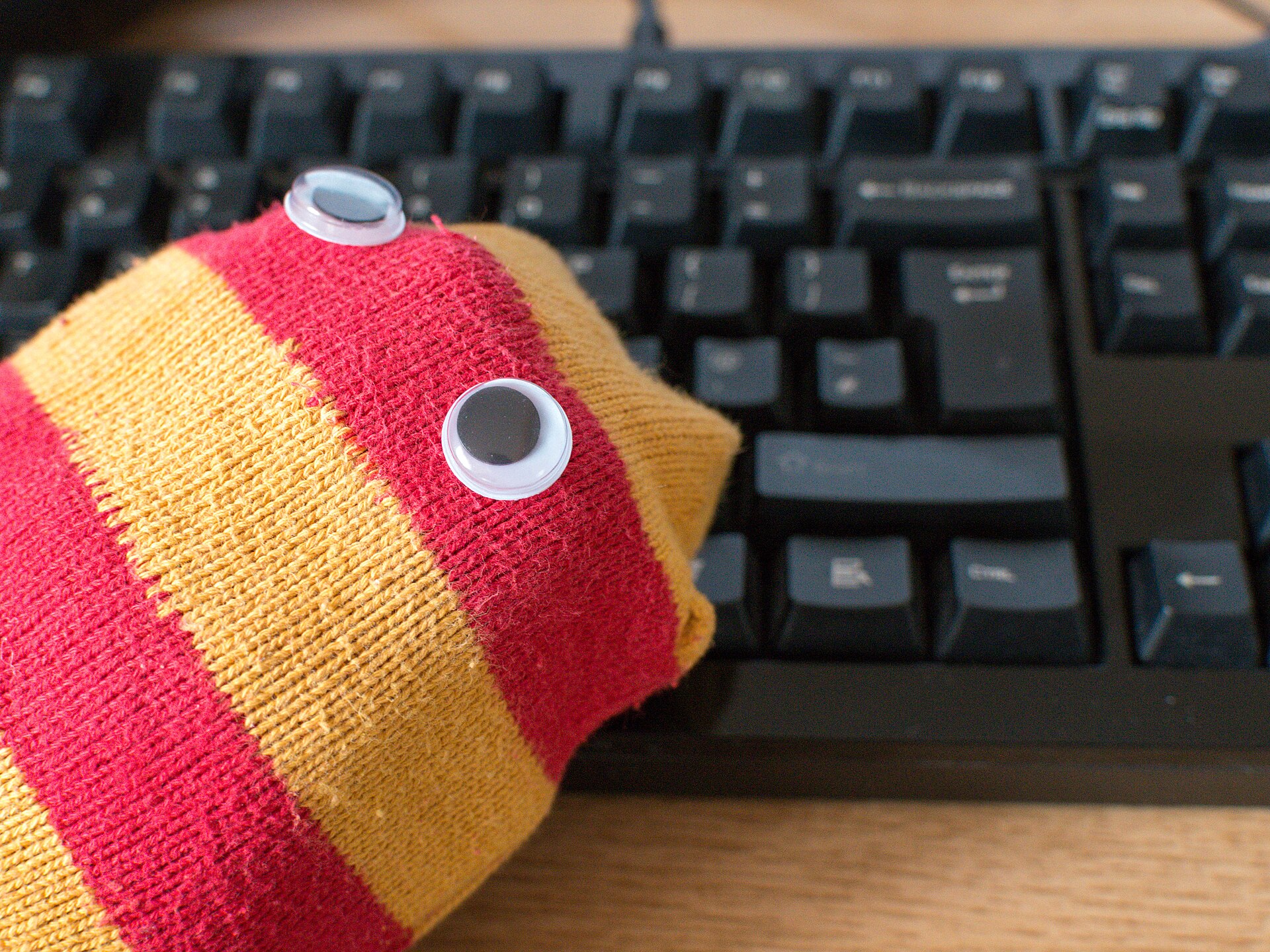 Red and yellow striped sock puppet with googly eyes