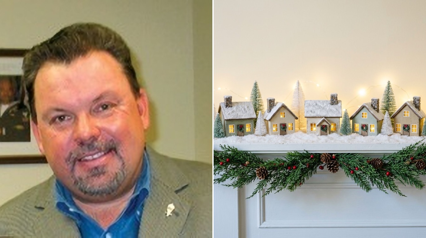 Thomas Kinkade Christmas cottage village on a white mantel next to a photo of the painter