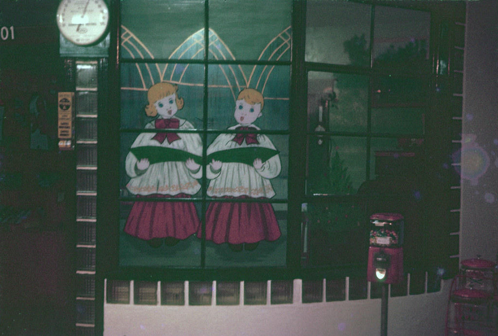 Two carolers painted on a vintage shop window