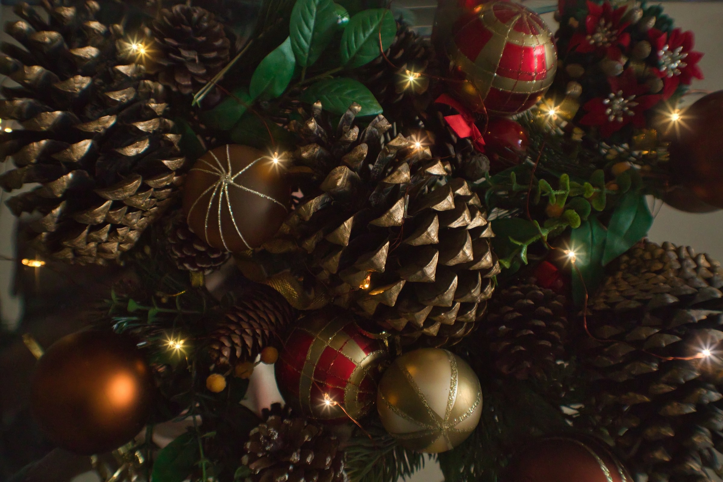 Christmas tree topper ideas from nature: gold brushed pine cones among ornaments