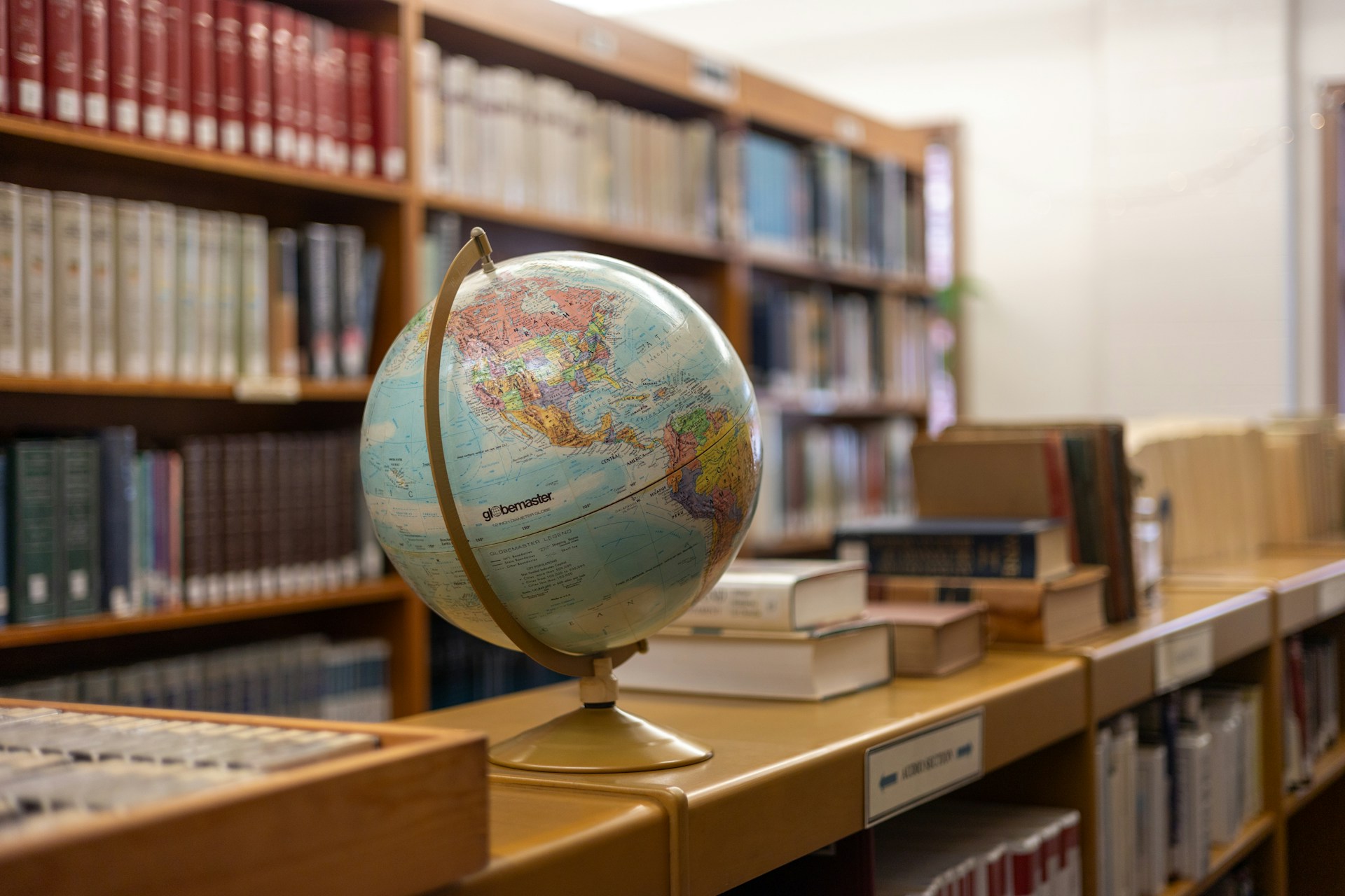 Desk globe on a wooden shelf in a library