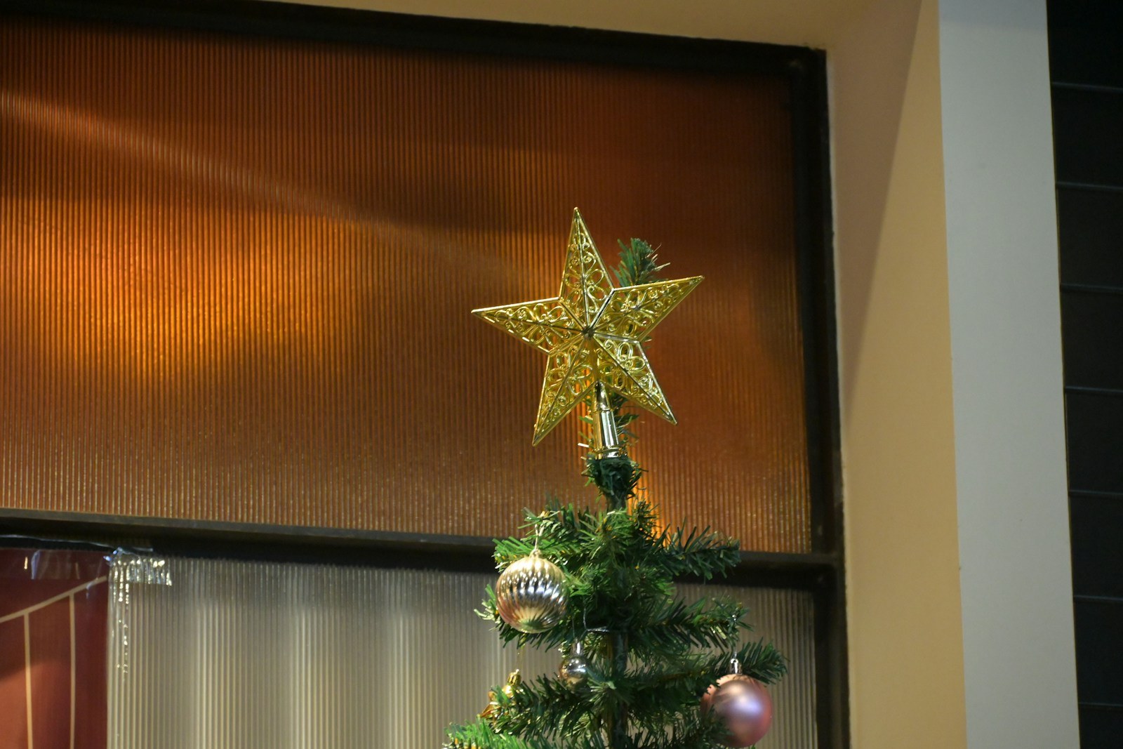 Golden star shining on top of a decorated Christmas tree
