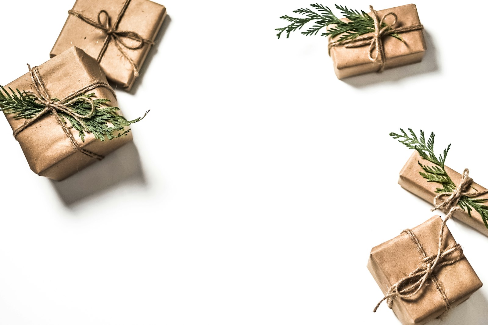 Kraft paper wrapped gifts tied with twine and tucked with evergreen sprigs