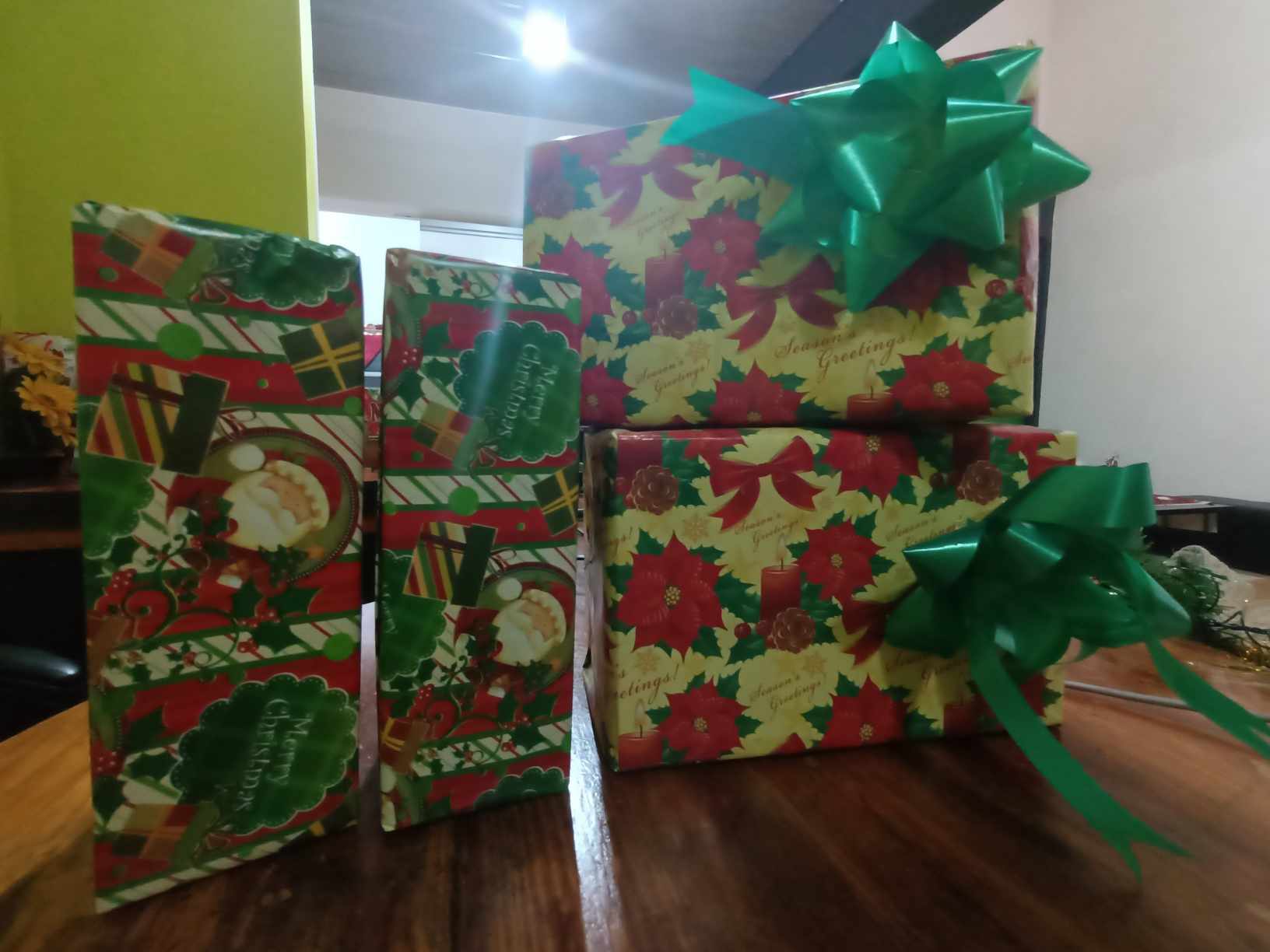 Stack of big wrapped Christmas presents with green bows