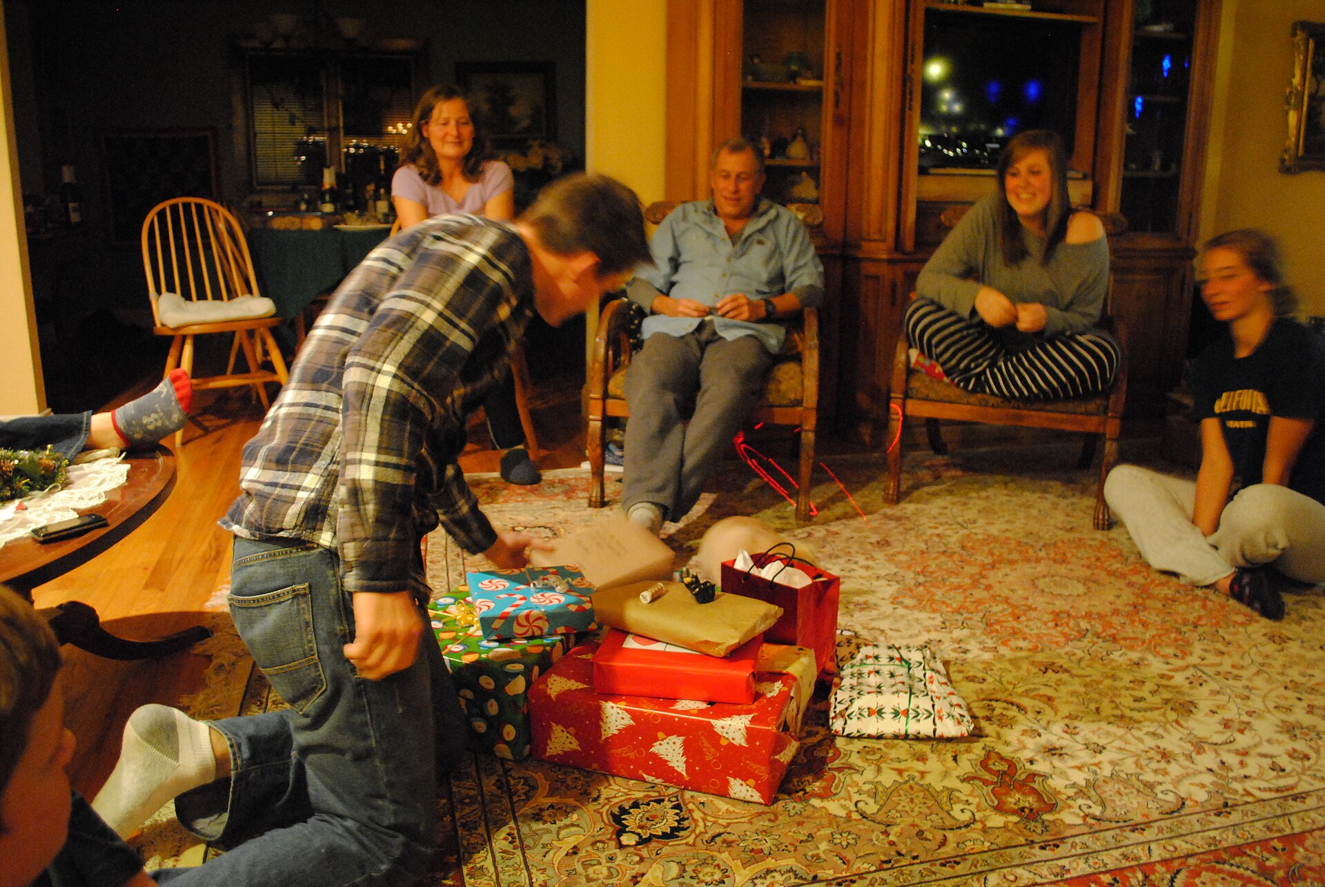 Friends opening gifts at a white elephant gift exchange in a living room