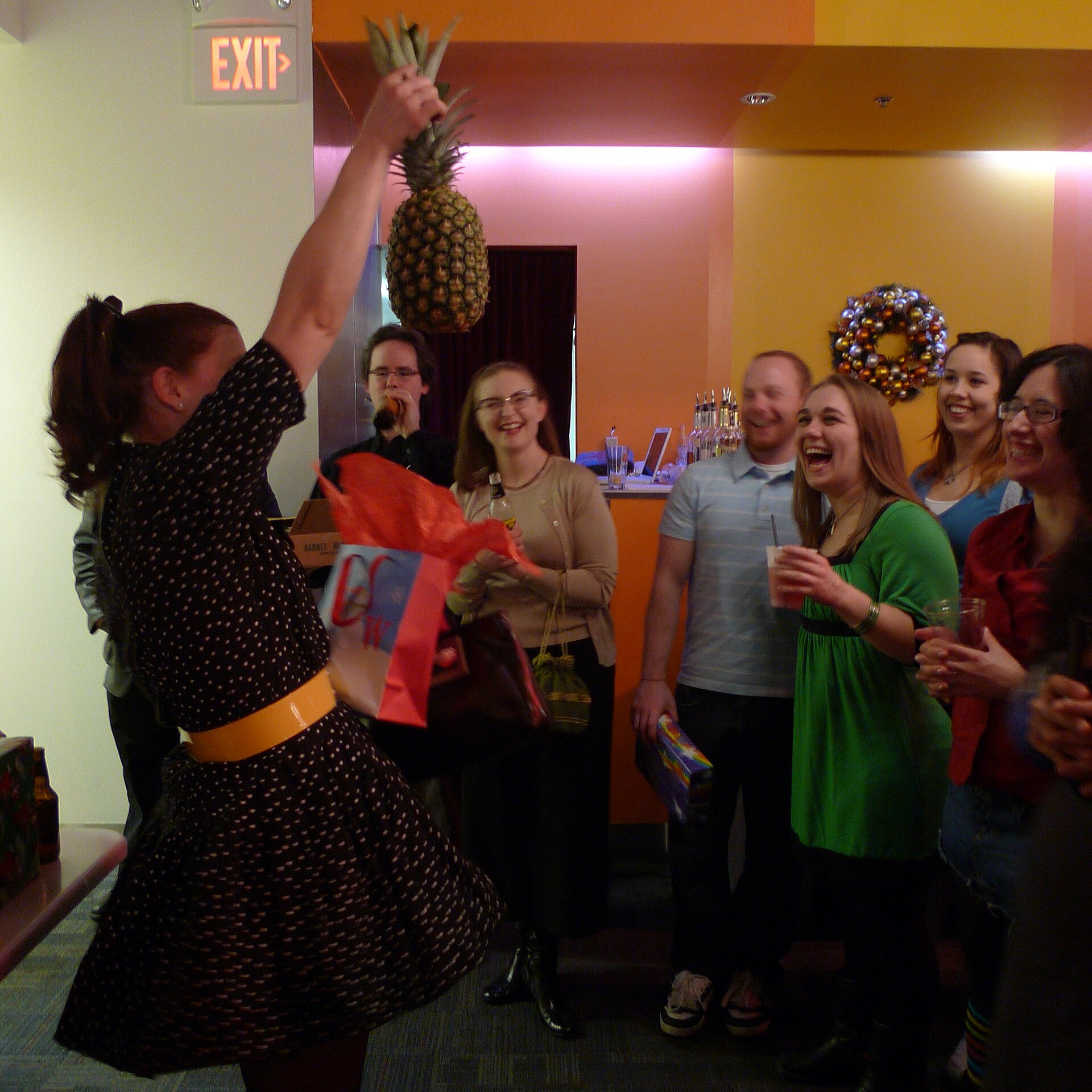 Guest holding up a pineapple at a white elephant gift exchange