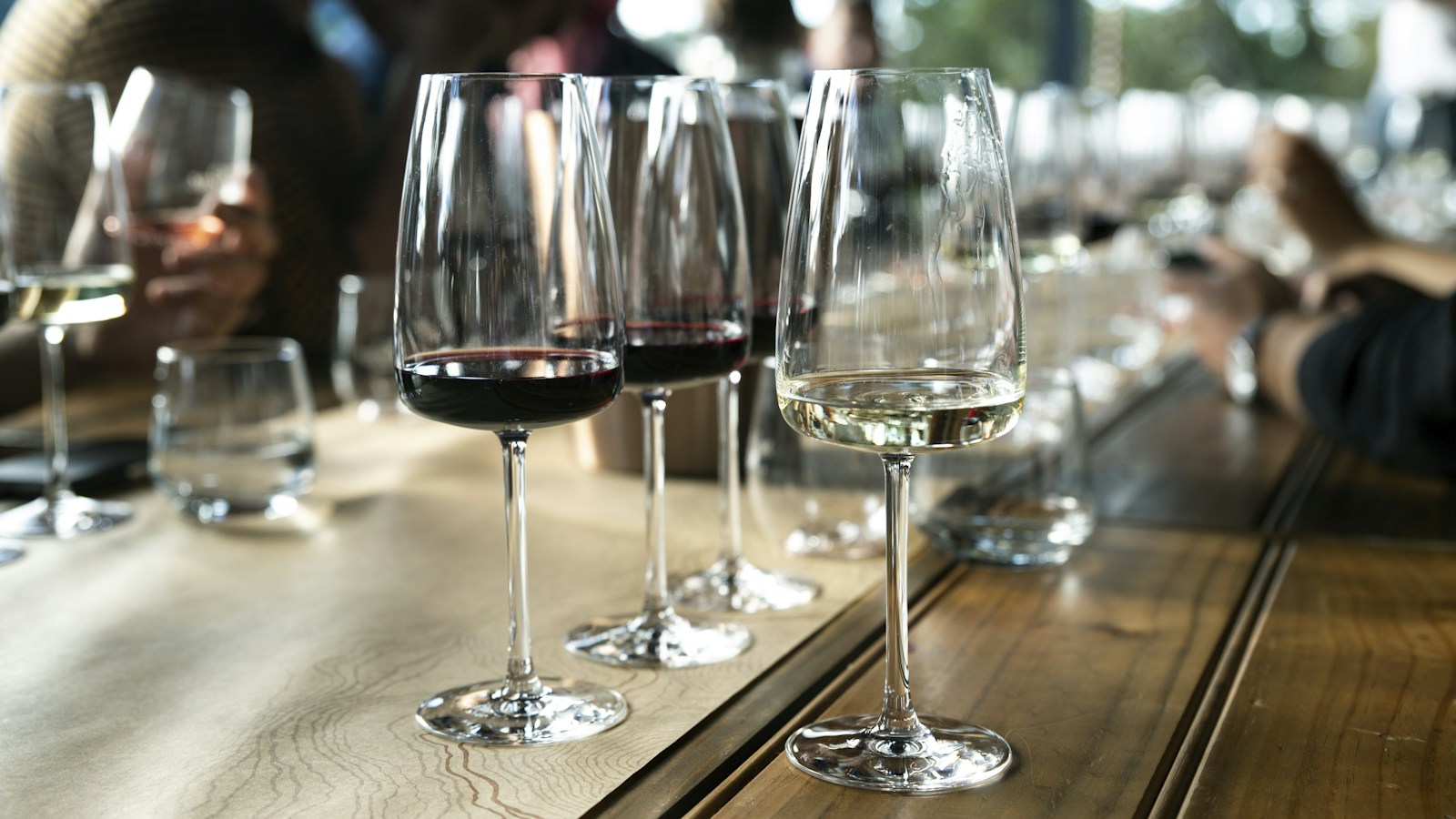 Clear stemmed glasses lined up on a dinner table