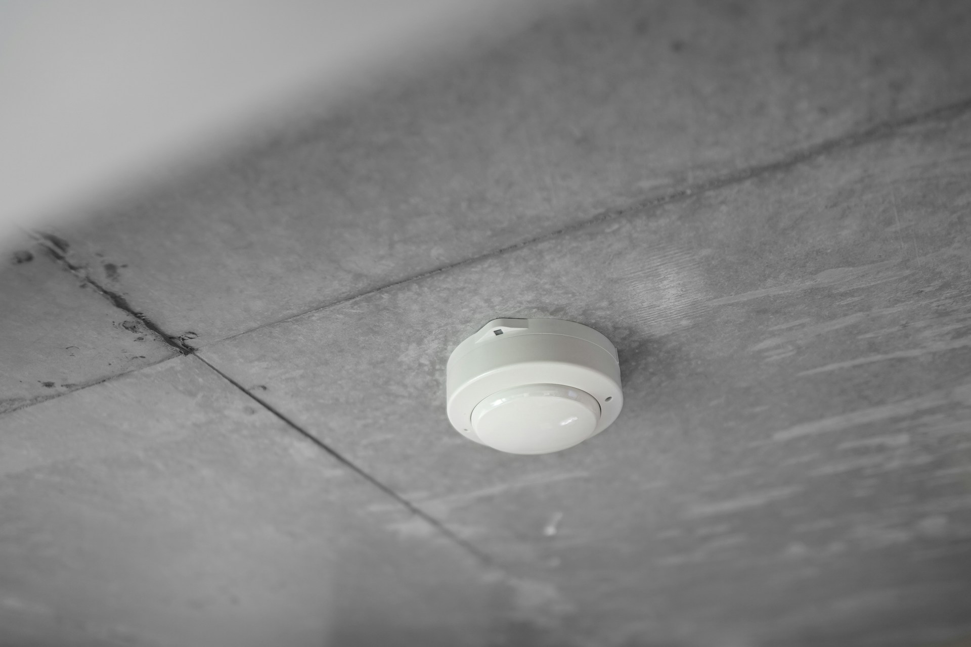 Round alarm mounted on a white ceiling
