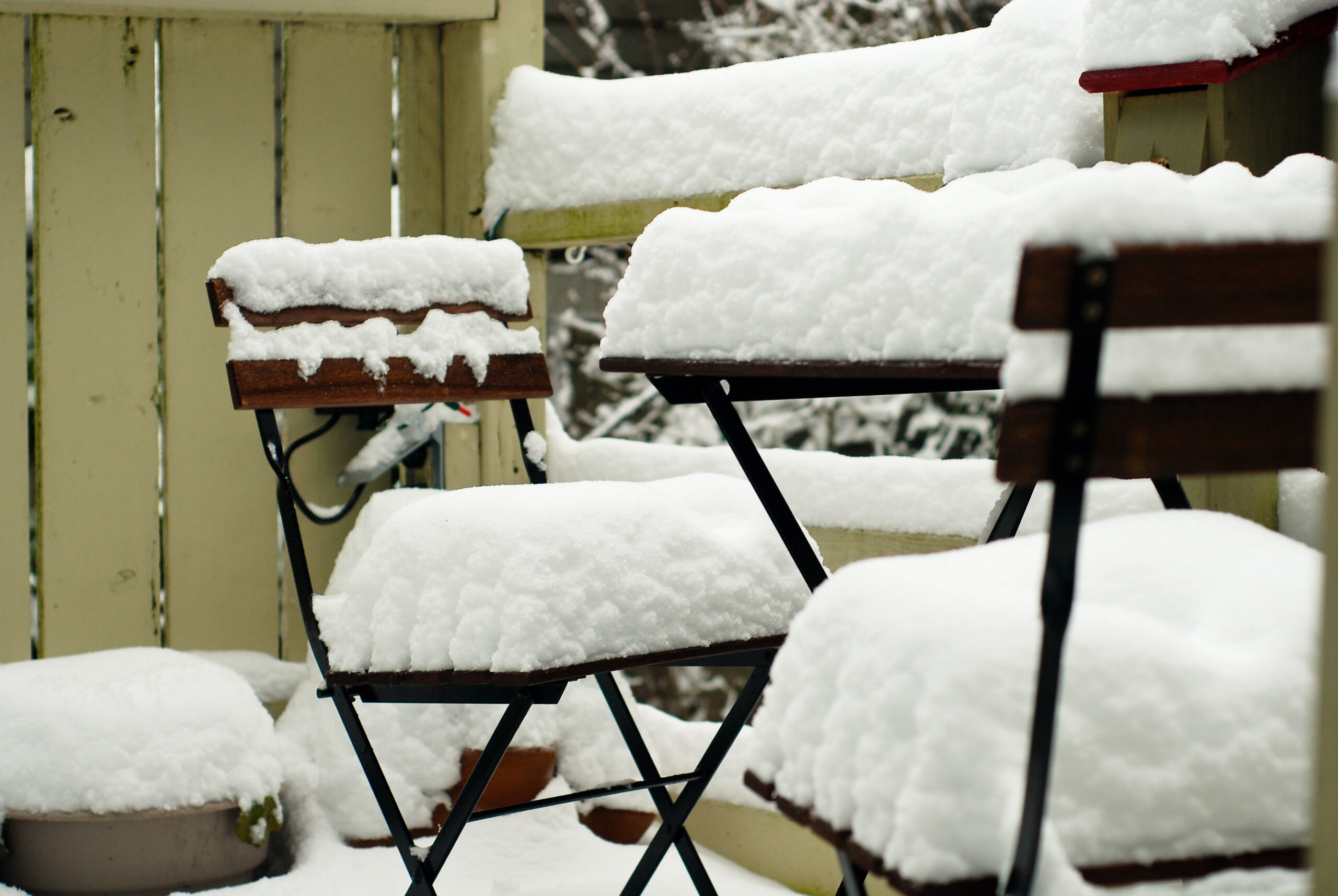 Patio table and chairs buried under fresh snow