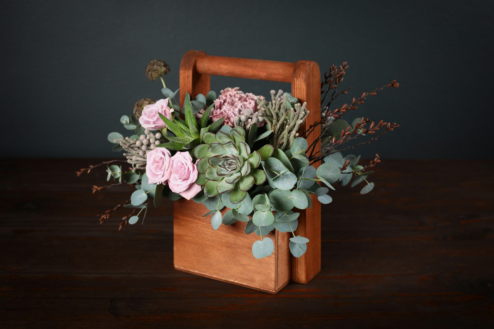 Wooden box planter filled with succulents and pink roses