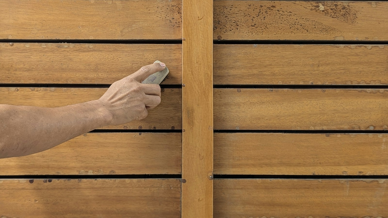 Hand sanding a board with a sanding block