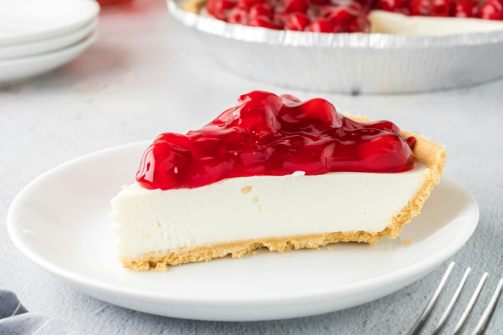 Slice of New York cheesecake with cherry topping