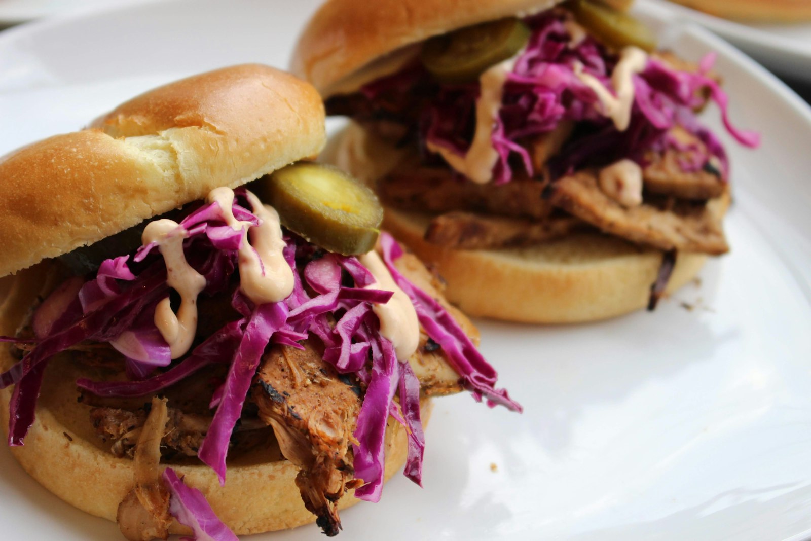Pulled pork sandwiches piled with purple cabbage slaw