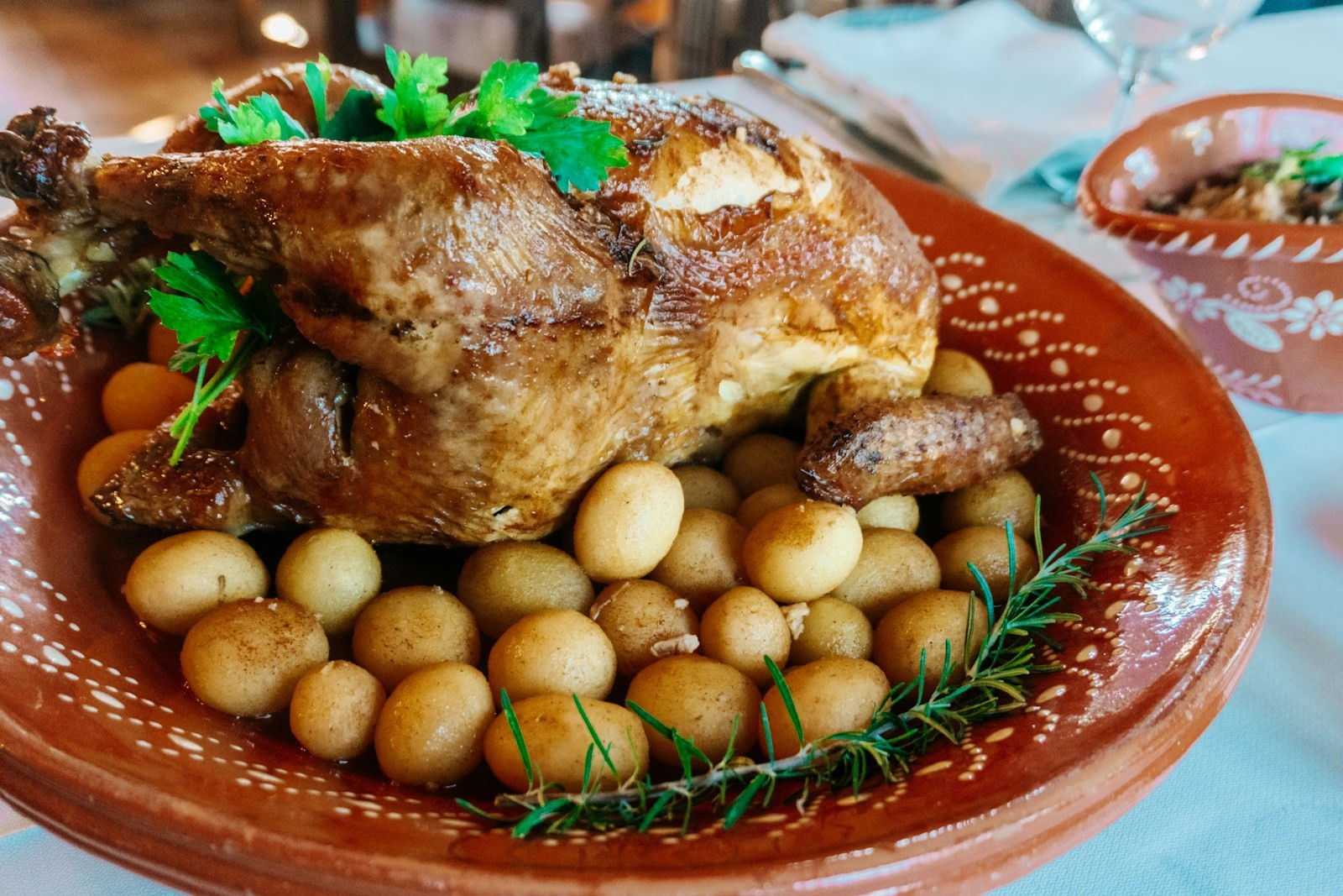 Portuguese roast bird with baby potatoes in a clay dish