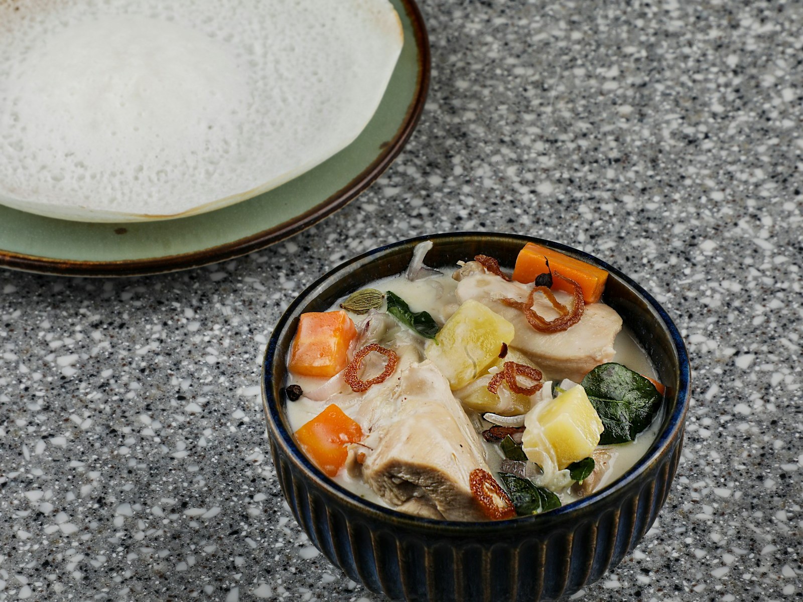 Bowl of creamy soup with potato, carrot and chicken pieces