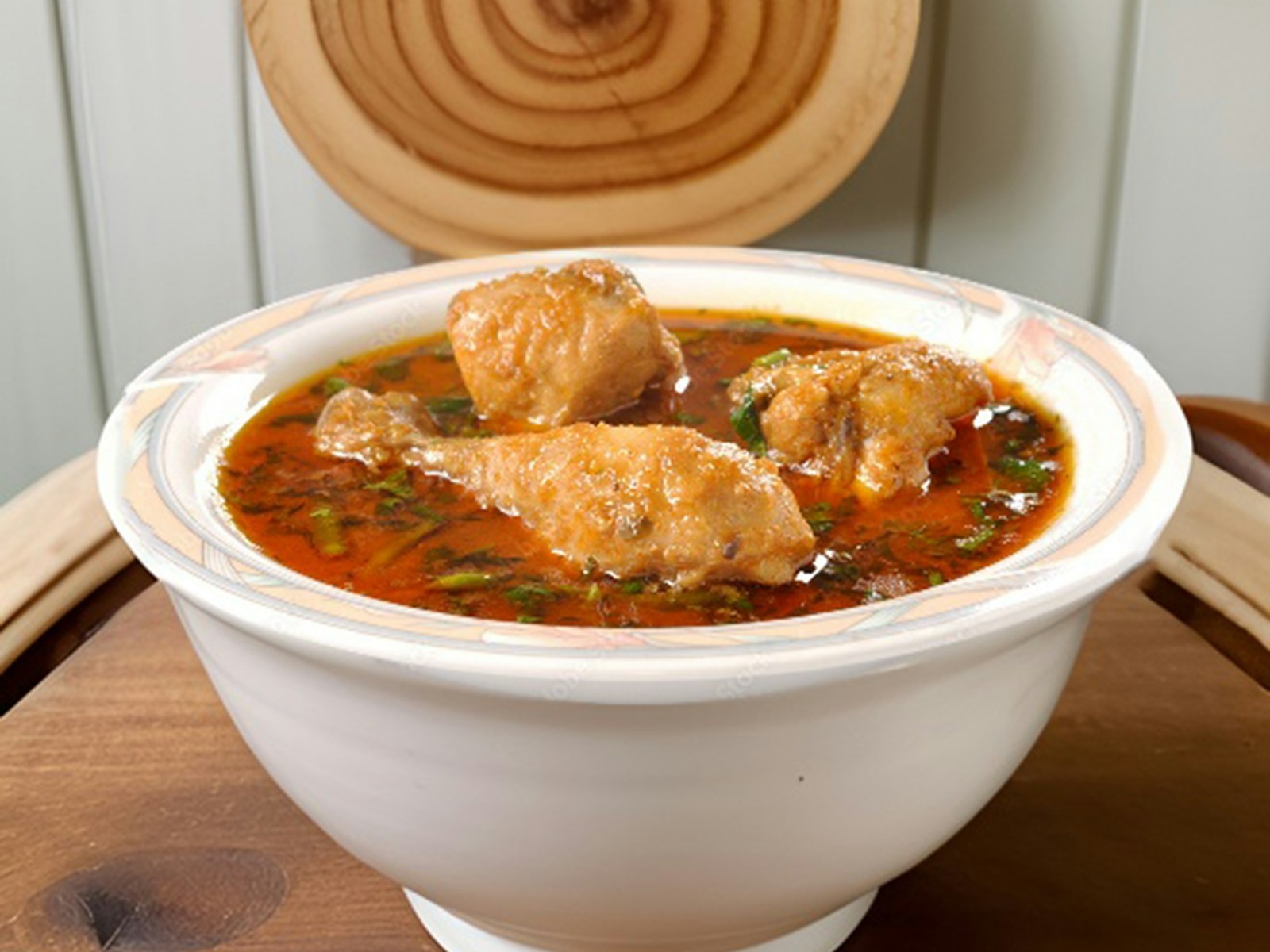 Bowl of homemade stew with greens in a red broth