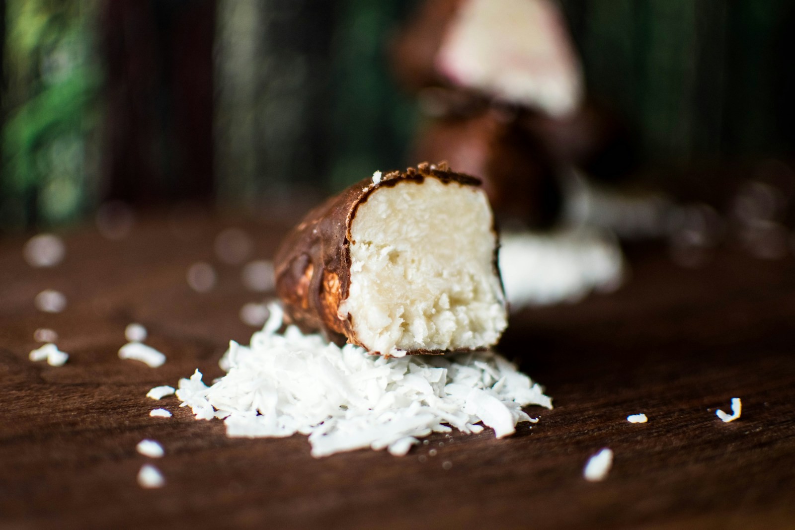 Chocolate dipped treat cut open next to shredded coconut
