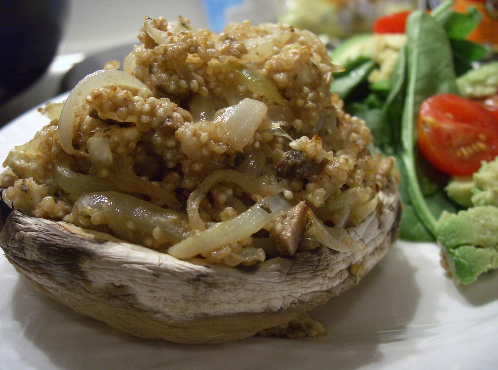 Portobello filled with spiced quinoa next to a green salad