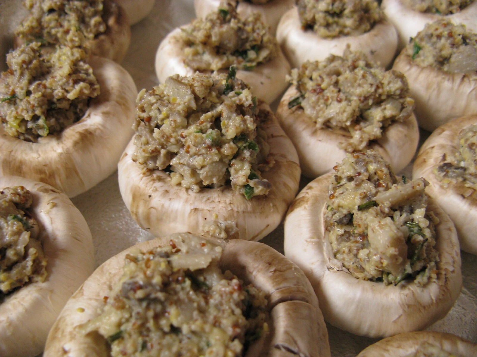 Unbaked stuffed mushrooms filled with herby bread stuffing