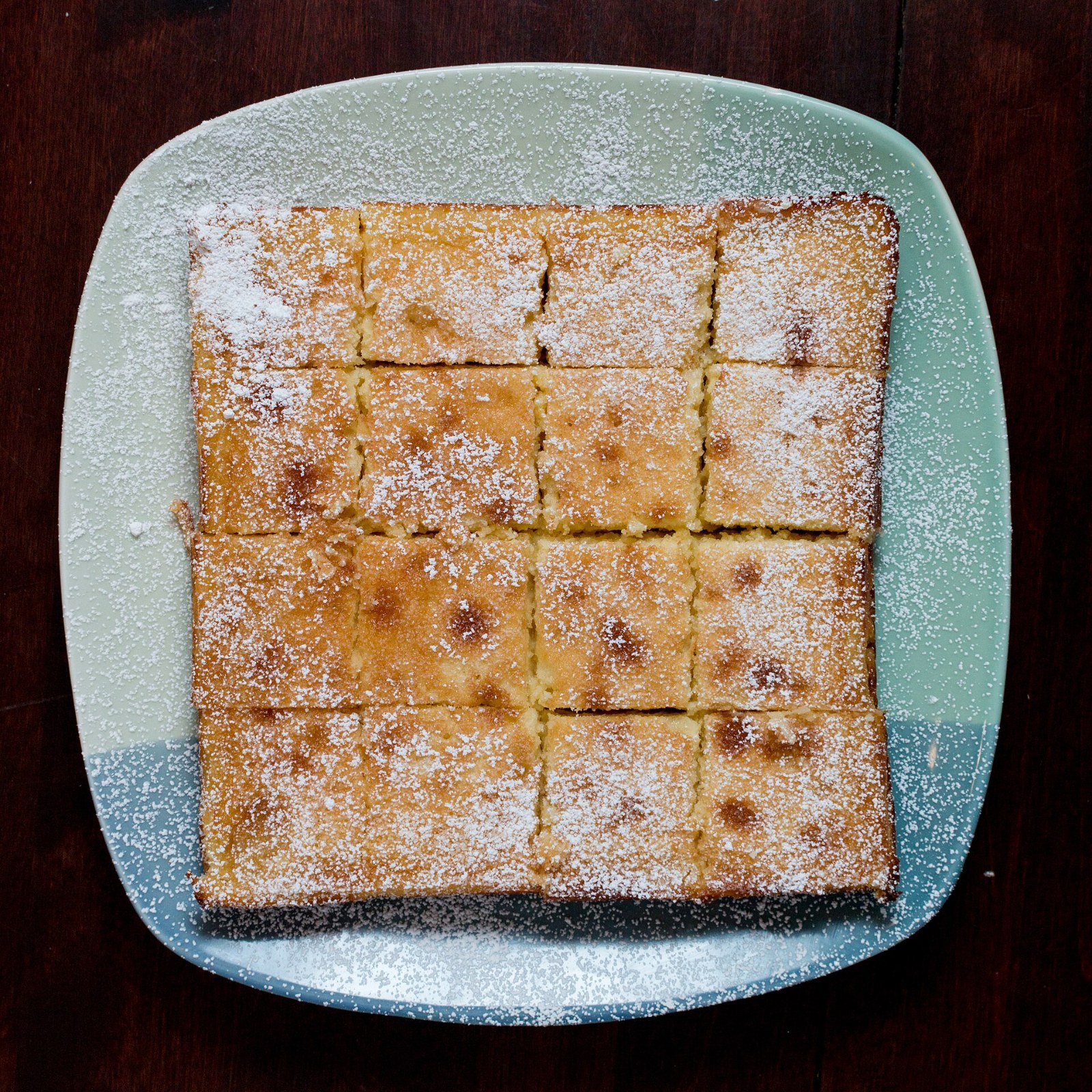 Pan of lemon squares dusted with powdered sugar and cut into neat squares