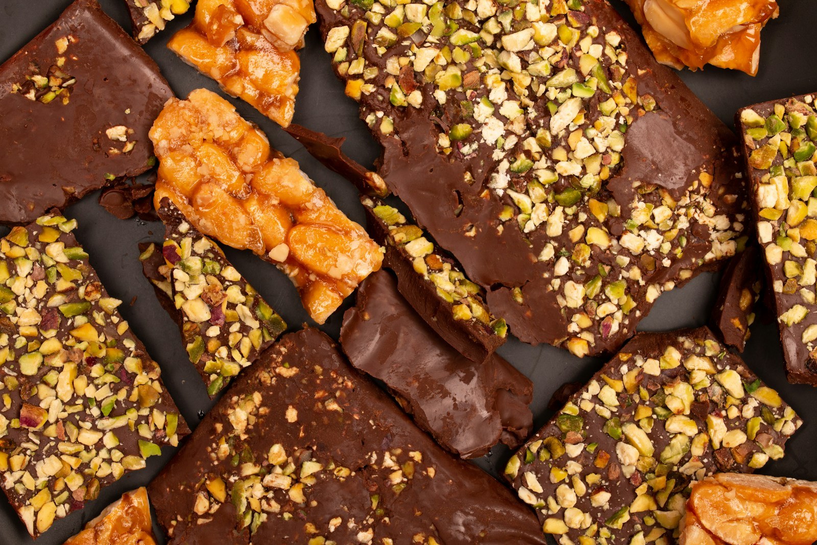 Pieces of chocolate toffee bark topped with chopped pistachios and almonds