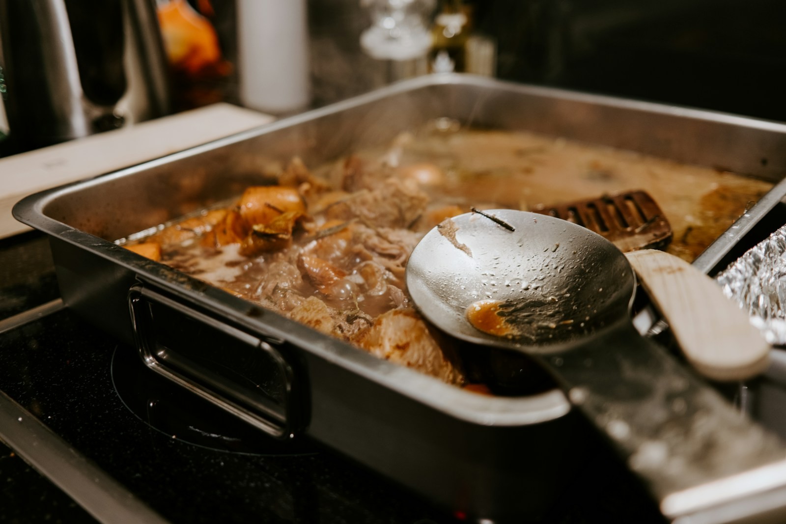 Roasting pan full of turkey drippings with a ladle