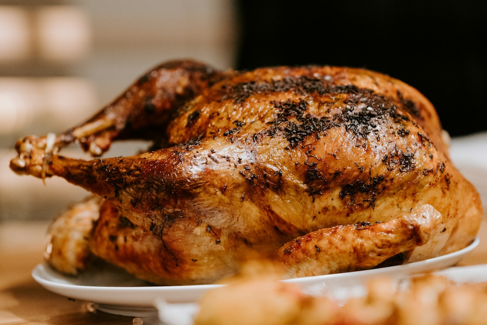 Golden wet brined Thanksgiving turkey on a white platter