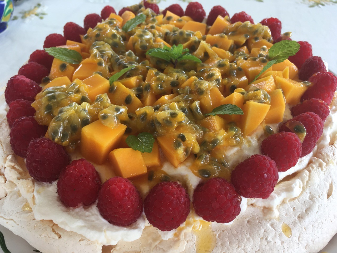 Pavlova topped with raspberries, mango and passion fruit