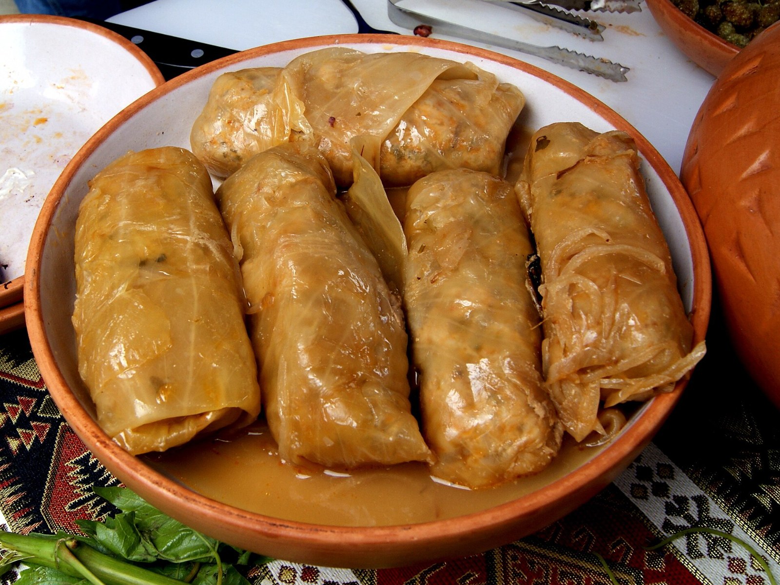 Stuffed cabbage rolls simmered in a clay dish