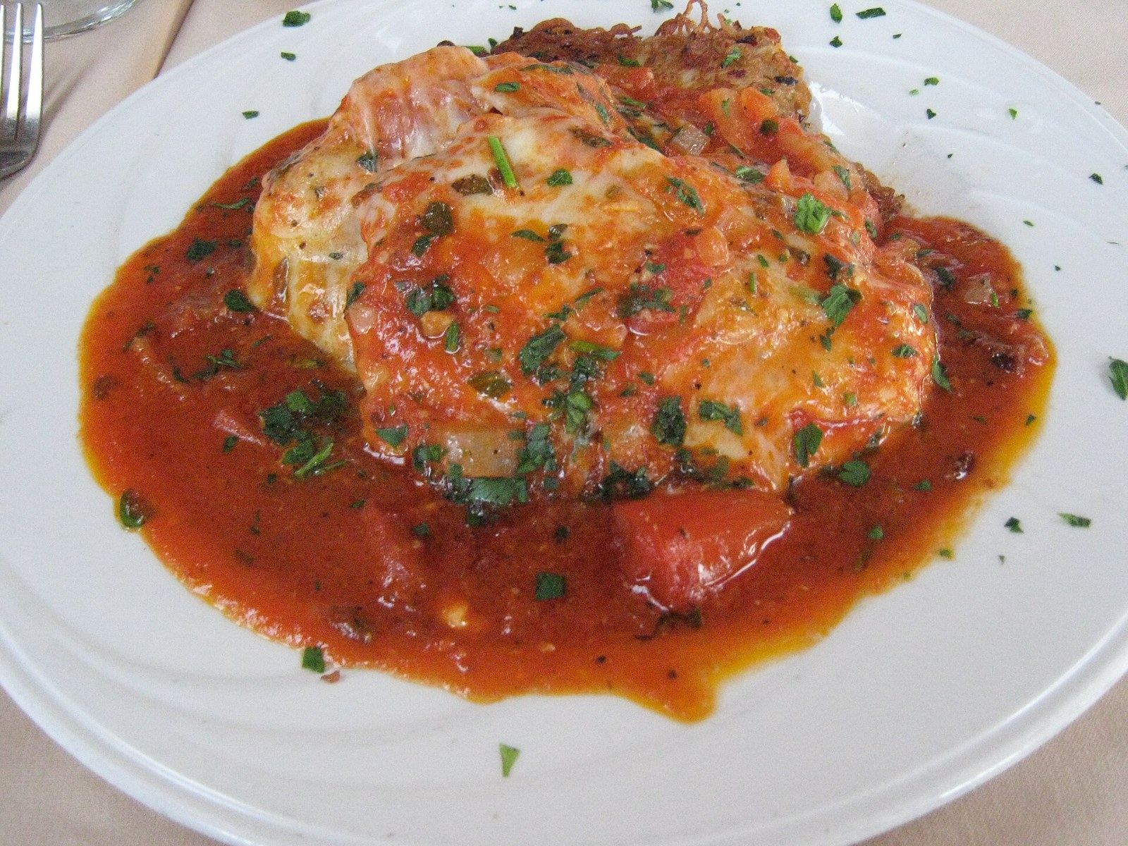 Chicken cutlet topped with tomato sauce and melted cheese