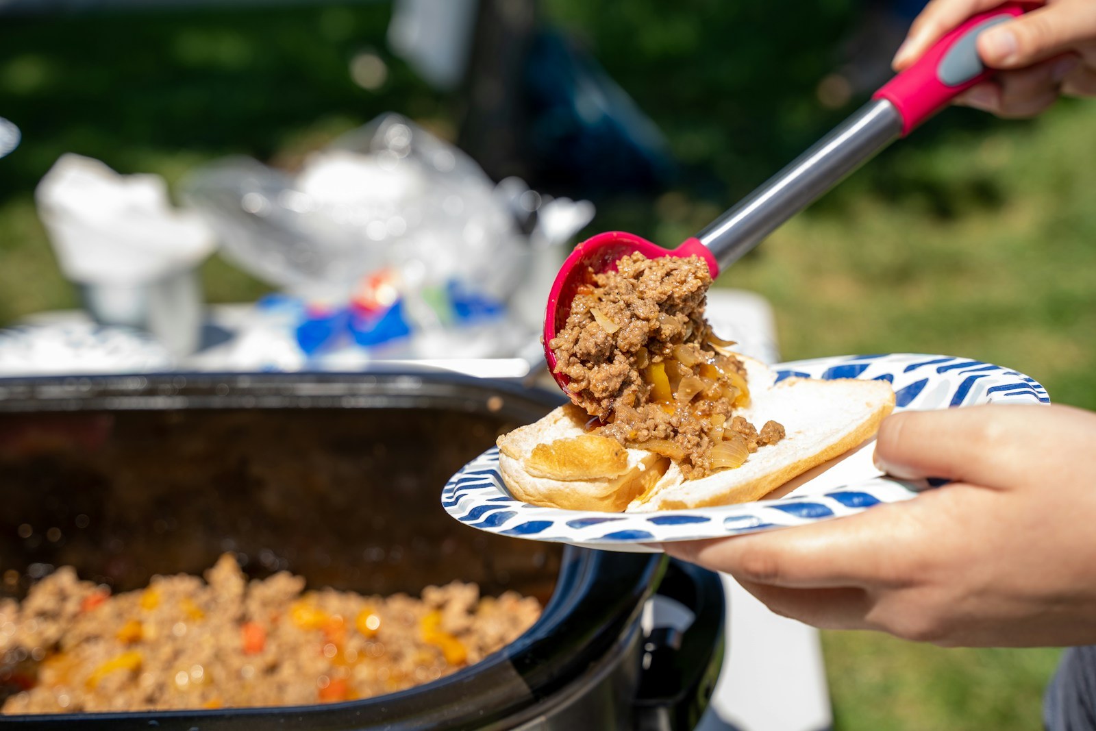 Sloppy joe filling scooped from a slow cooker onto a plate