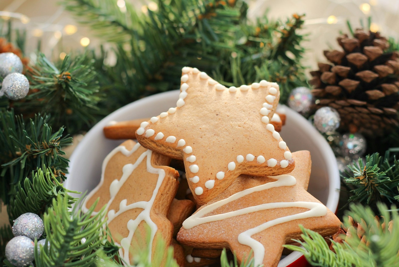 Iced gingerbread stars in a bowl with pine branches