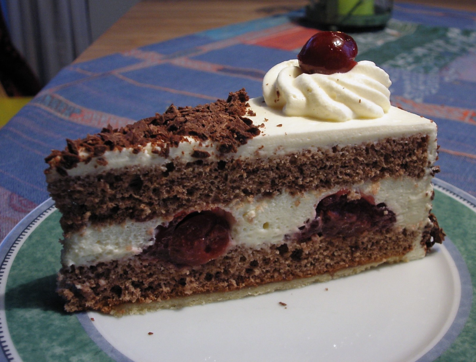 Slice of German Schwarzwälder Kirschtorte with cream, cherries and chocolate sponge