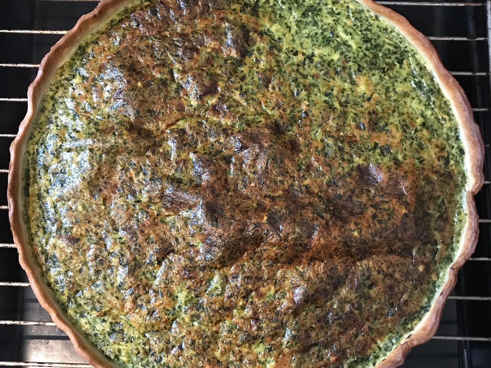 Golden spinach quiche bake in a tart pan for breakfast for dinner