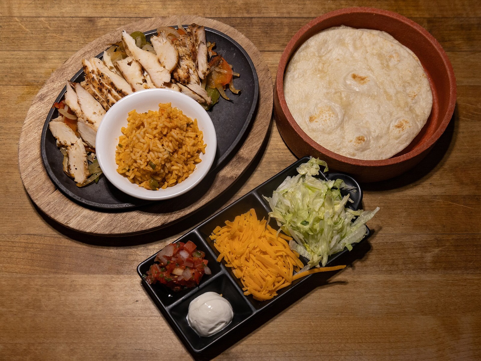 Chicken fajita platter with tortillas, rice and toppings