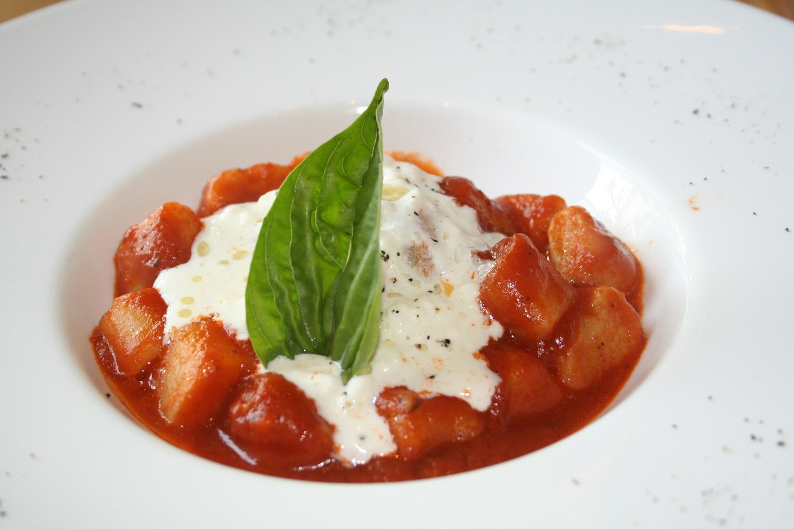 Gnocchi in tomato sauce with creamy cheese and basil