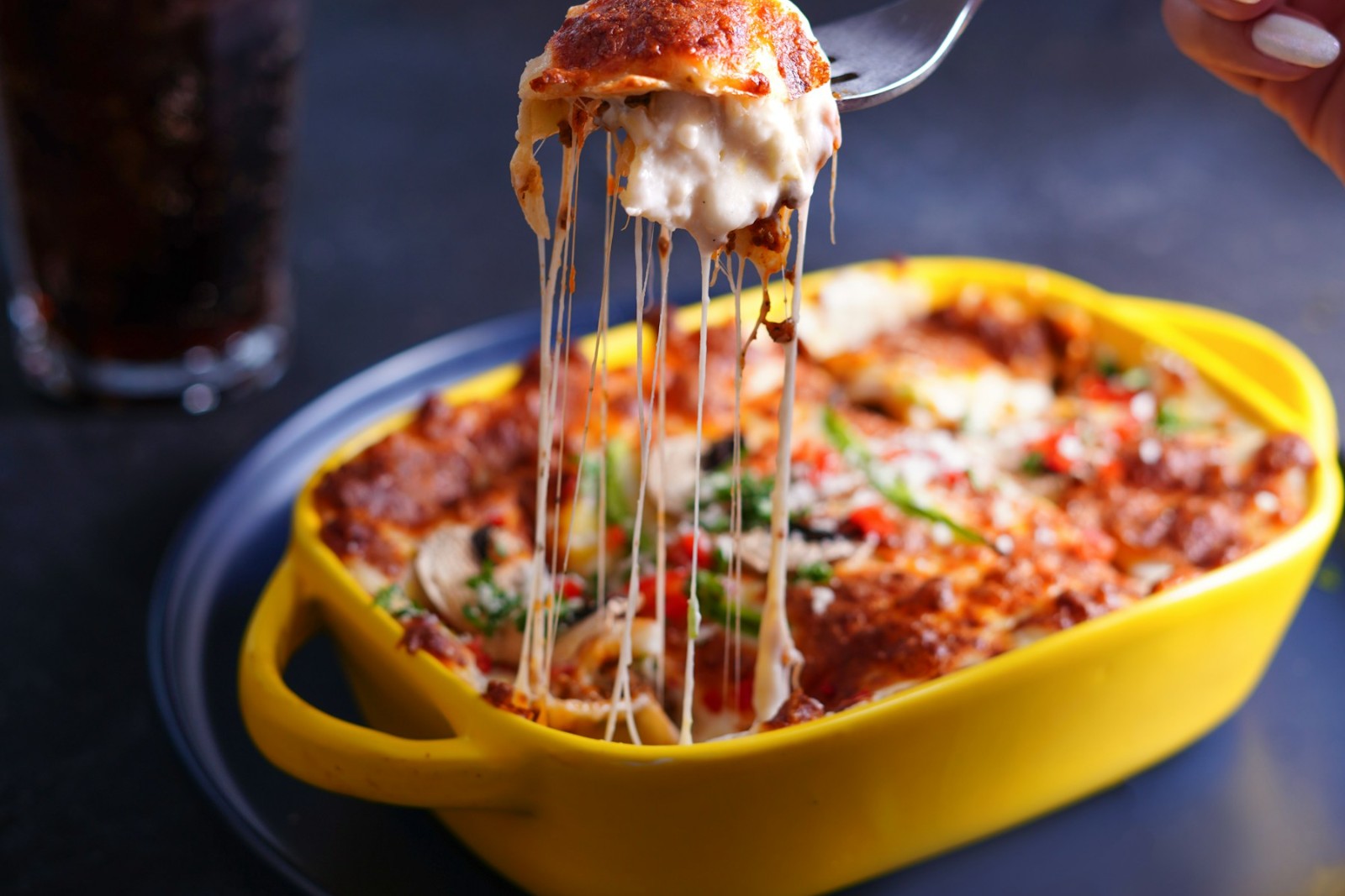 Cheesy lasagna lifted from a baking dish