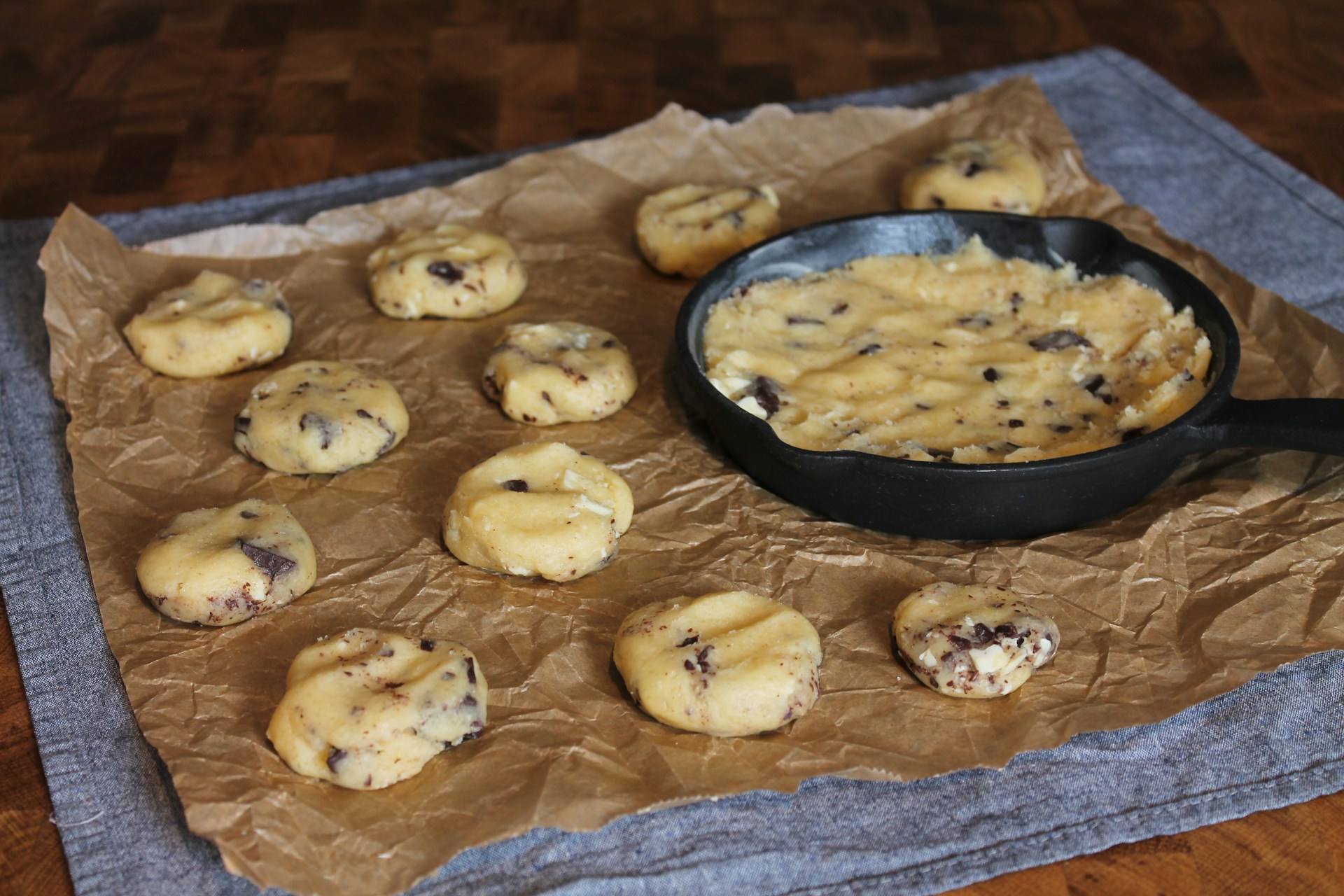 Dough balls and a small cast iron skillet pressed with chocolate chip dough