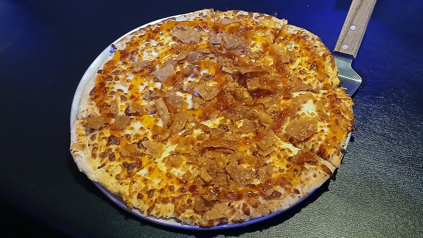Crab rangoon pizza with a golden cheesy top at a restaurant table