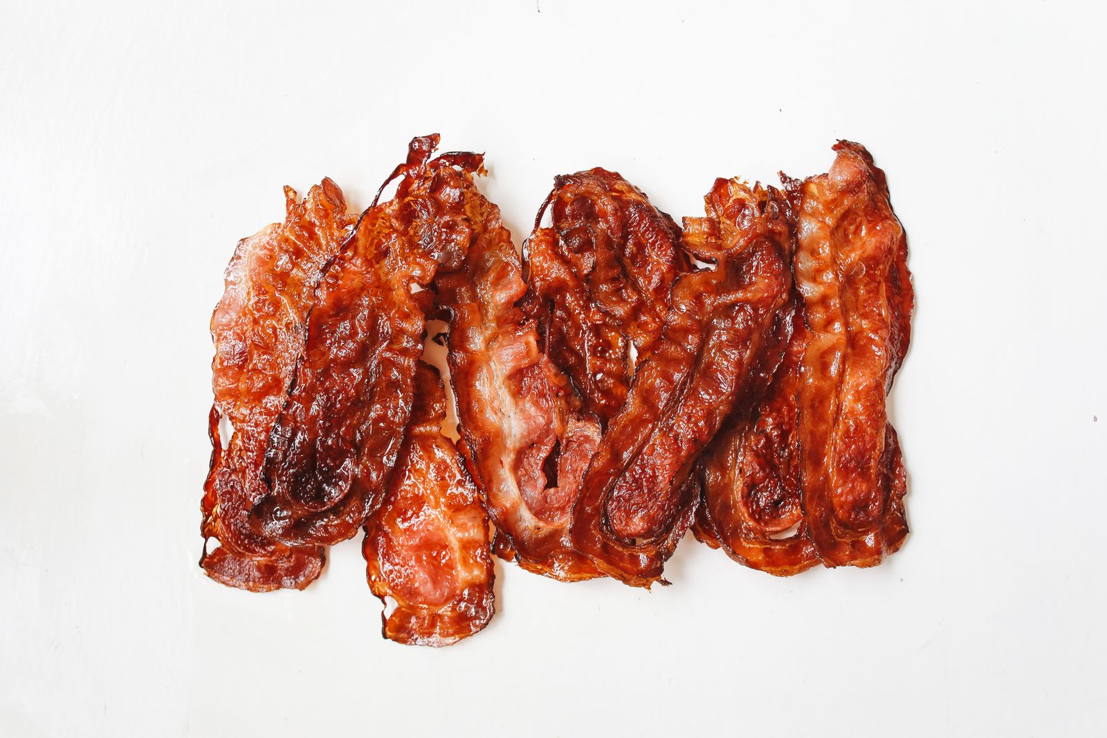 Air fryer hacks: crispy bacon strips on a white plate