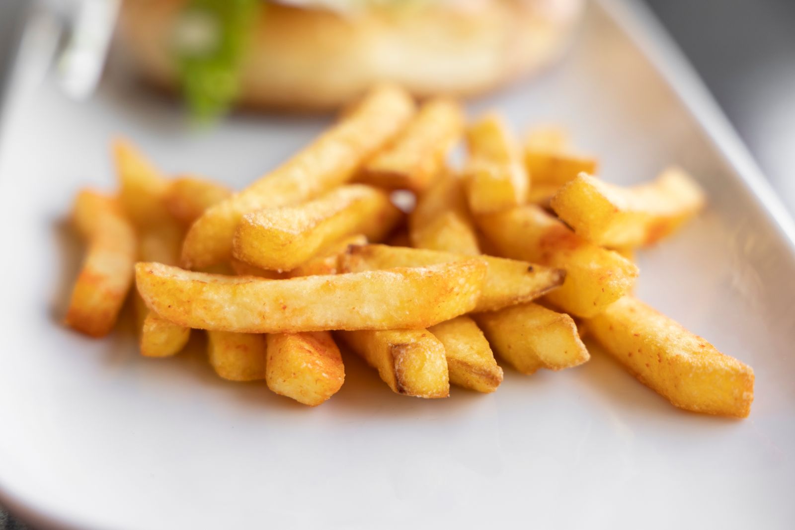 Golden french fries piled on a white plate