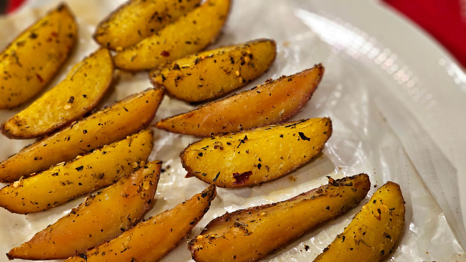Golden seasoned potato wedges on a tray