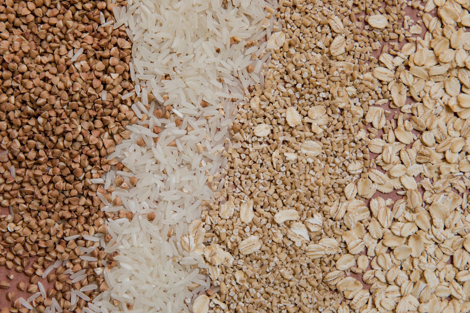 Whole grains like oats, buckwheat and rice in small piles