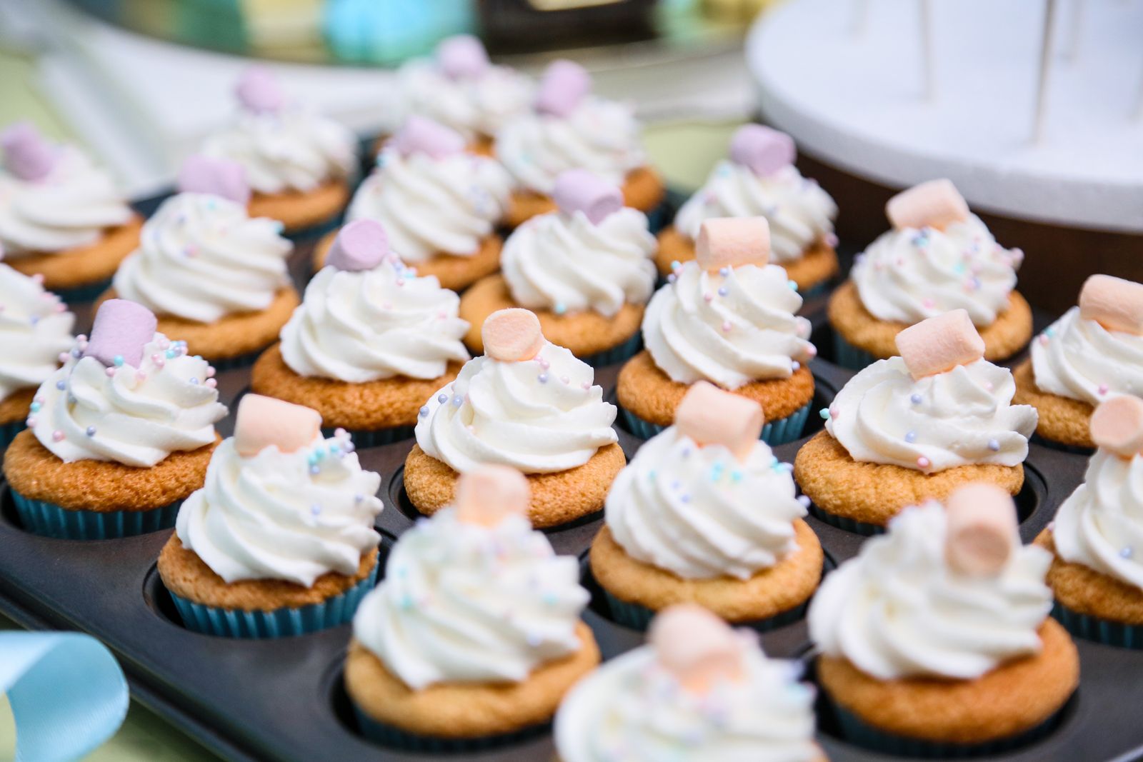Rows of cupcakes with fluffy white swirls