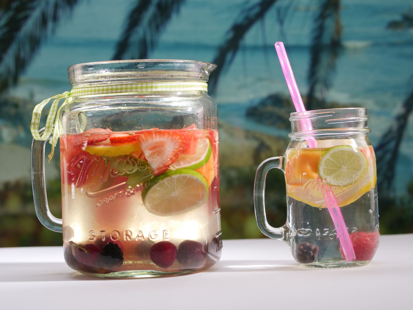 Fruit infused water in glass jars with straws