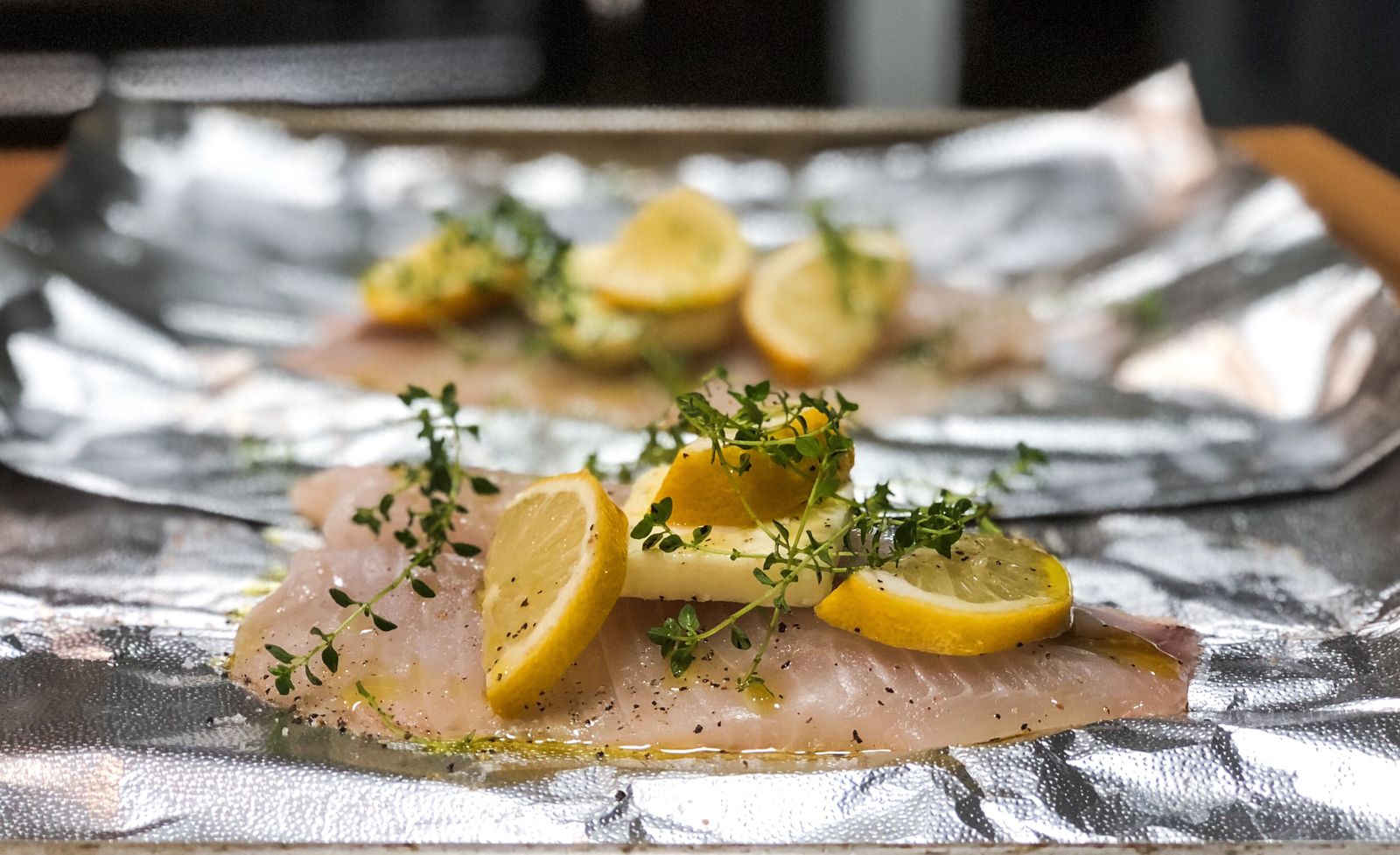 Cod fillets with lemon slices in foil packets